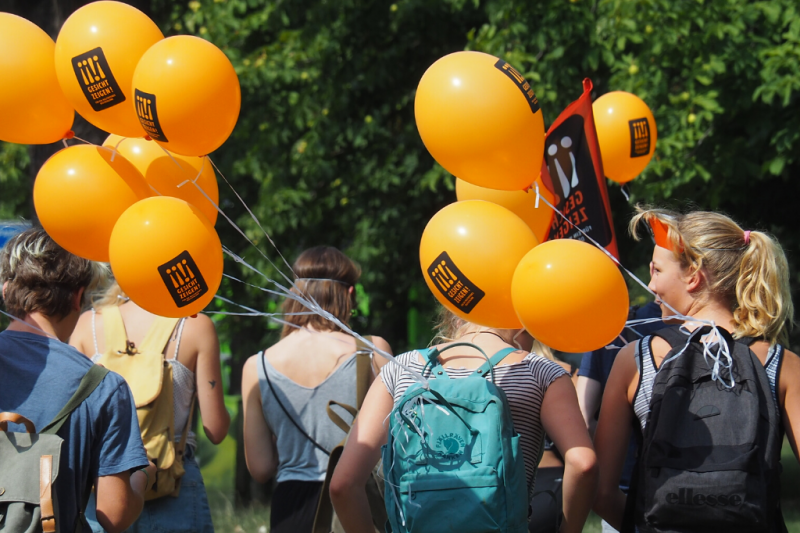 Eine Gruppe Personen mit Luftballons von Gesicht Zeigen