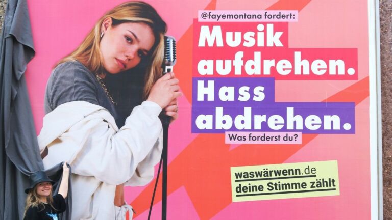 Plakat von einer Musikerin mit dem Text "Musik aufdrehen. Hass abdrehen".