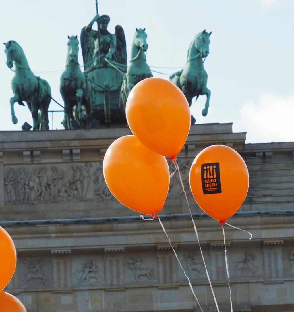 Drei Gesicht Zeigen Ballons vor dem Brandenburger Tor