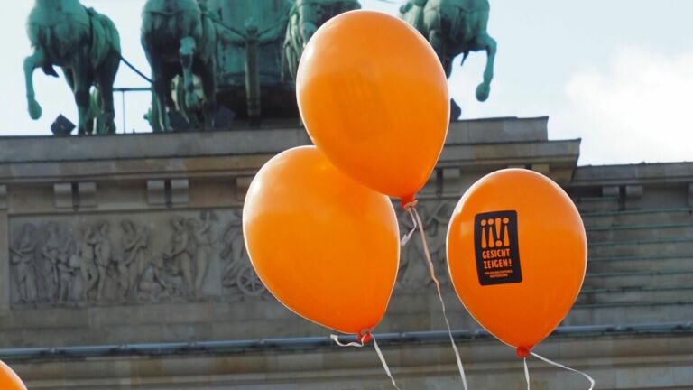 Drei Gesicht Zeigen Ballons vor dem Brandenburger Tor