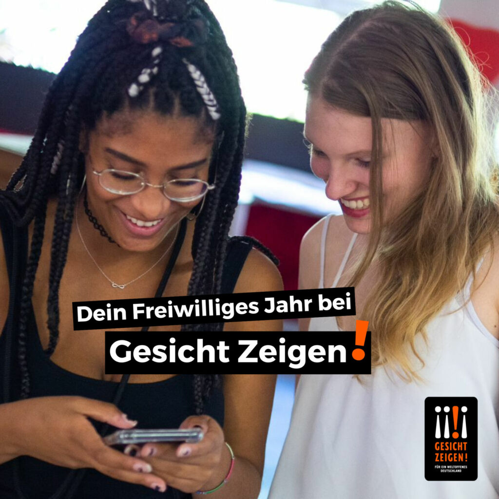 Zwei junge Frauen schauen lächeld auf ein Handy. Auf dem Foto steht "Dein Freiwillighes Jahr bei Gesicht Zeigen!